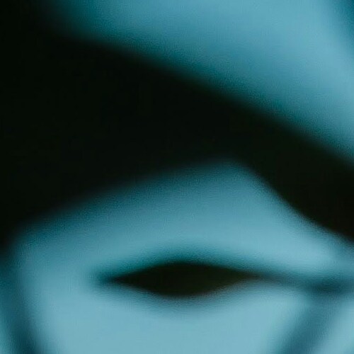 A close-up of a person's eye shrouded in shadows, evoking mystery
