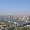 A vibrant downtown scene in Cairo with modern buildings, bustling streets, and a mix of traditional and contemporary architecture under a clear blue sky