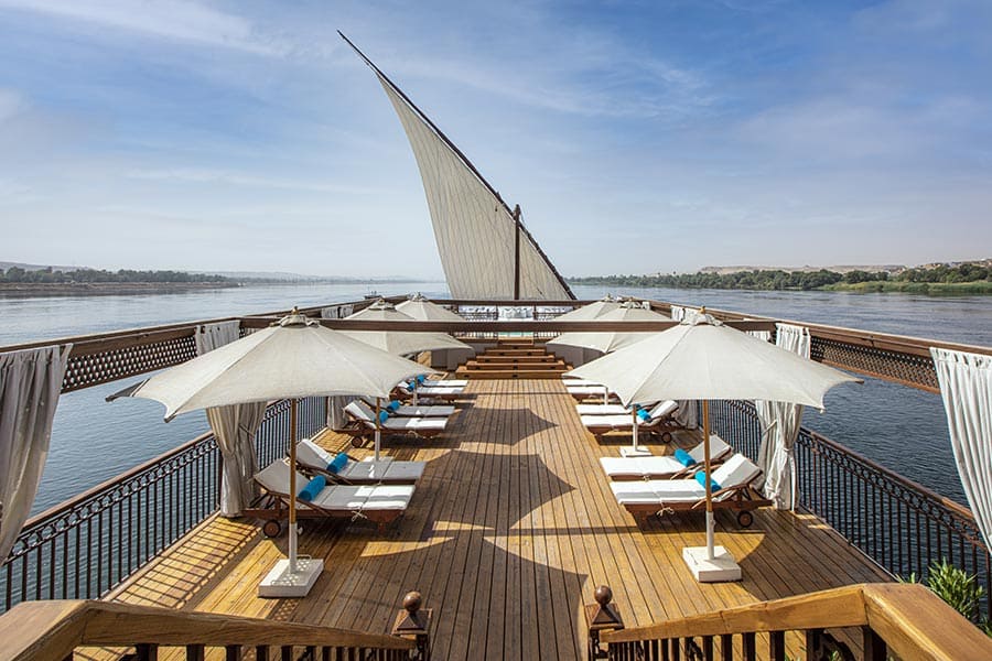 Luxurious lower sun deck lounge with a jacuzzi, modern seating, and scenic views of the Nile River