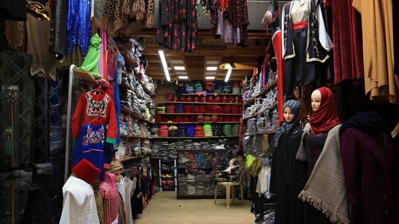 A clothing shop featuring mannequins in traditional attire, surrounded by shelves of colorful fabrics and garments